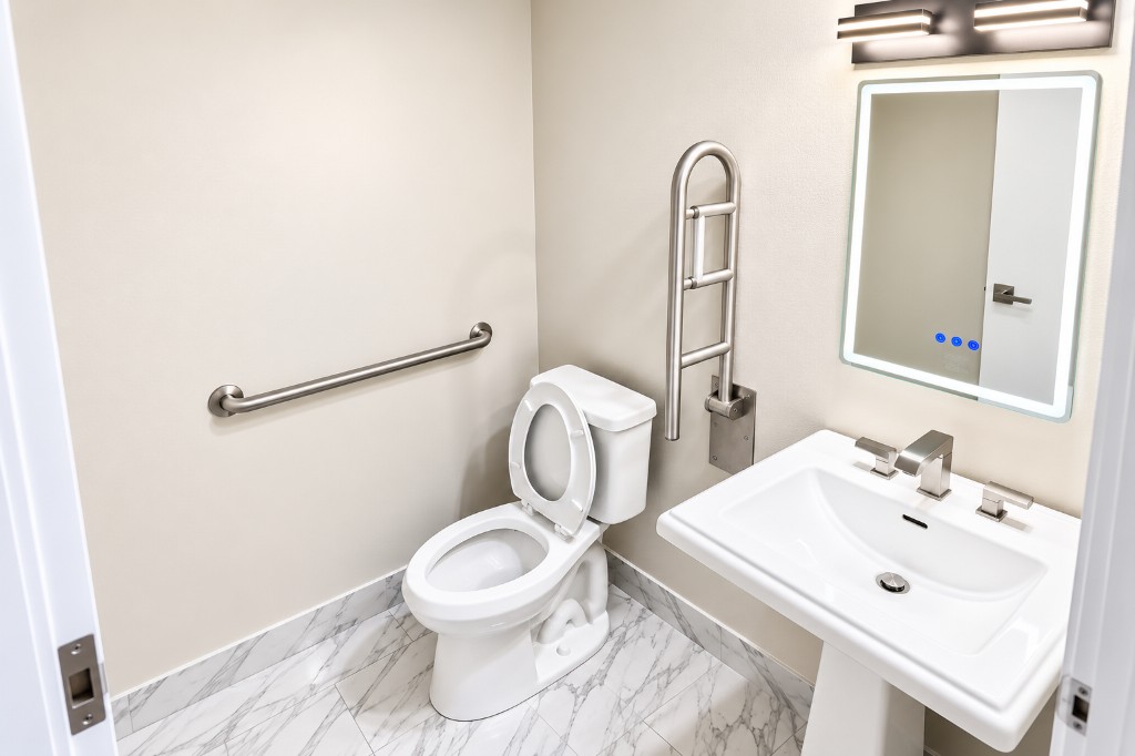 Private ½ bathroom with toilet, sink, and grab bar
