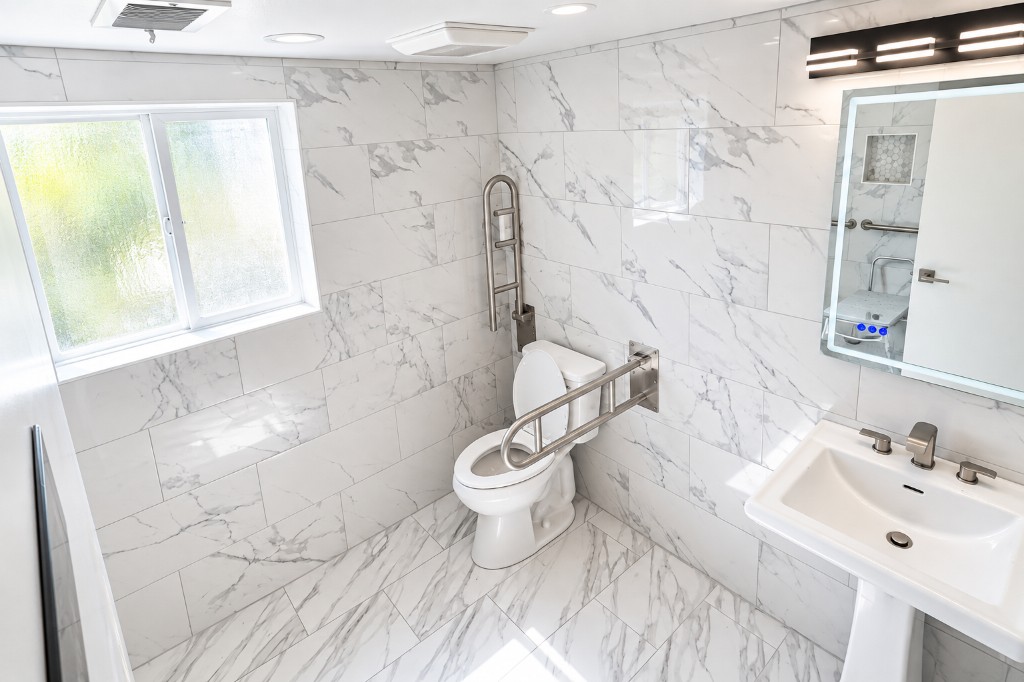 Bathroom with natural light, toilet, and grab bars